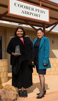 Photo: At Coober Pedy airport: UTHSAC’s Glenys Dodd (left) after receiving the Gladys Elphick Award in Adelaide for her dedication and commitment to Aboriginal health with Priscilla Larkins, UTHSAC’s CEO, who, on a separate occasion, won the Aboriginal nurses/midwife category of the 2013 South Australian Nursing and Midwifery Excellence Awards. Photo courtesy UTHSAC