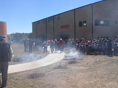 Children gathererd out the front of school during a smoking ceremony