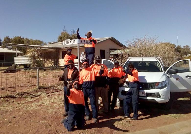 Eight men celebrating the first street signs for a community in the APY Lands
