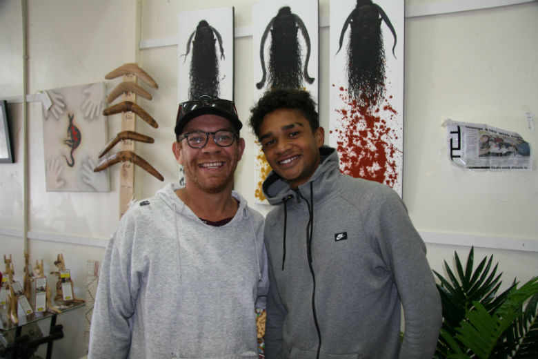 Two young men smiling to camera in an art shop
