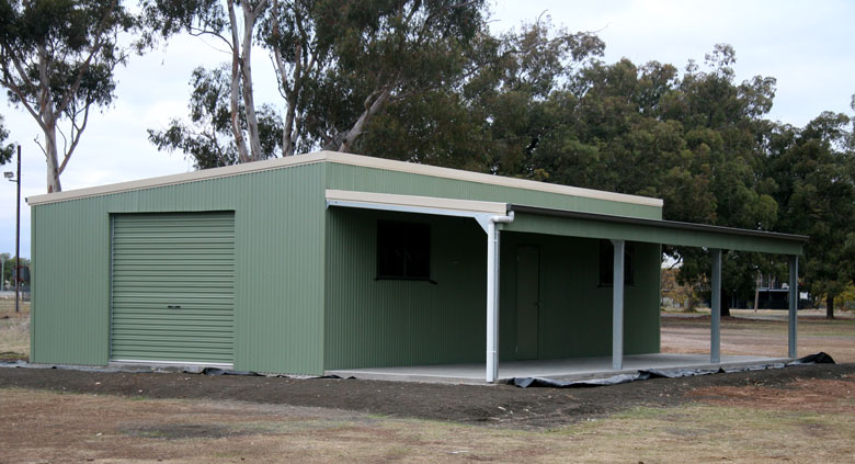 Green colourbond shed under tall trees