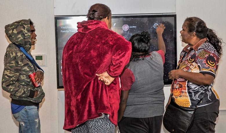 Yindjibarndi people around a wall-mounted touchscreen inside Ganalili Centre, Roebourne