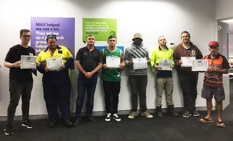 Seven Aboriginal construction workers receive their Certificate II; an eighth man stands with them