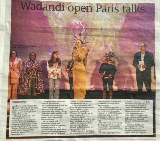 A scan of a newspaper article with the headline Wadandi open Paris talks and a photo of 6 people standing on a stage while a woman stands in front with a microphone 