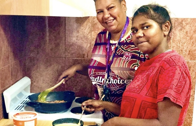 Two people cooking at a stove