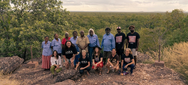 A group of people poses in a bush setting