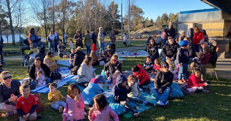 A large group of people having a picnic on a lawn